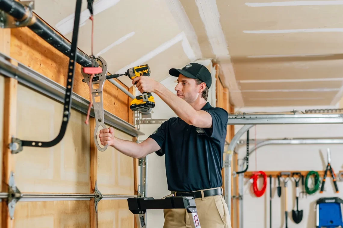 Garage door technician repairing broken springs Garage door technician repairing broken springs